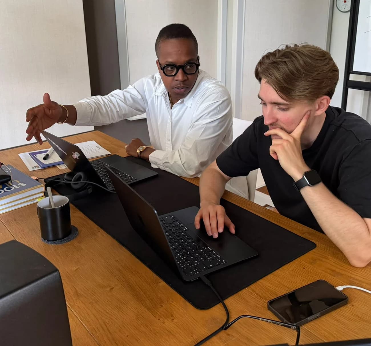 Patrick Mashegwana und Henrik Horn am Schreibtisch vor zwei Laptops